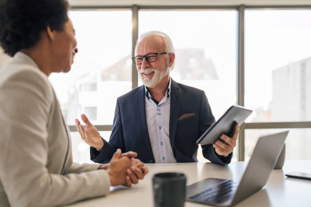 istock Elderly professional planning strategy with female partner over digital tablet. 1409478865