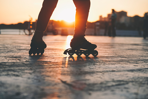 Closeup of Rollerblader at a park at sunset time with blurred people at background