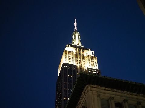 New York, USA - June 22, 2019: The top of the Empire State Building, illuminated during the evening.