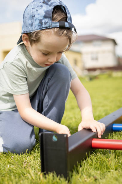 istock 4 year old boy on the lawn learning to assemble a playground 1409479865