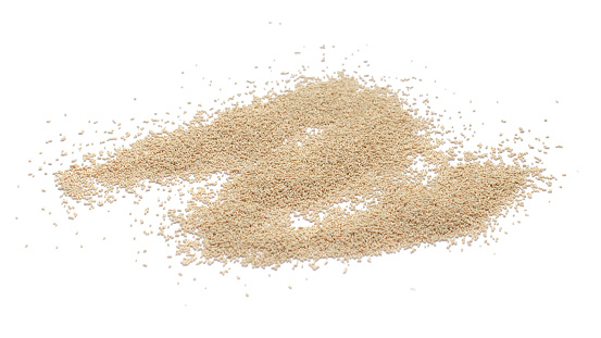 Pile of dry yeast isolated on white background, top view. Active dry yeast on a white background, top view. Dry yeast granules isolated on white background. Dry yeast is used in baked goods