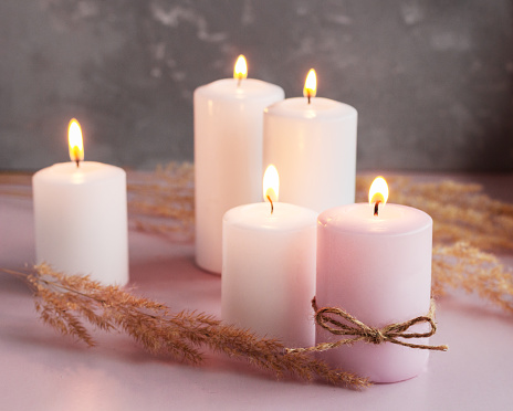 Set of white and pink wax candles with dried flowers, home decoration set.
