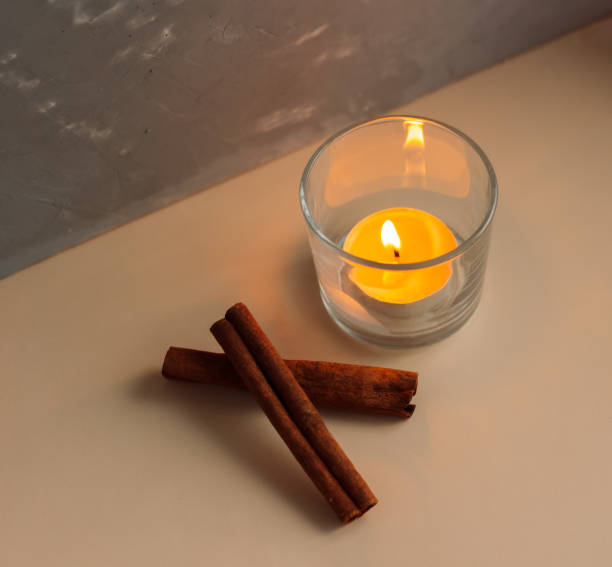 istock Burning little orange candle with cinnamon sticks 1409481513