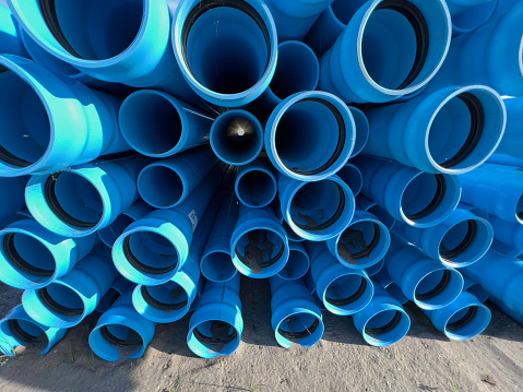 Underground pipes stacked waiting to be installed at a construction site for a new community.
