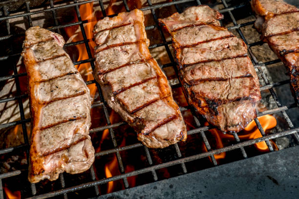istock Beef steaks grilling on a cast iron grlill plate on a camp fire. Campfire cooking. Outdoor BBQ 1409483018