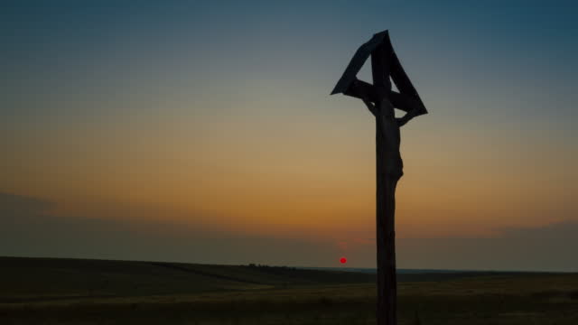 A Christian Cross on the field at sunset