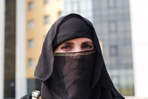 Muslim woman close-up portrait of her face in a black scarf on her head