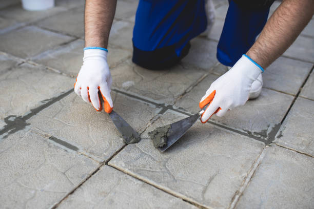 istock A man repairing the grout on a tile floor. 1409485646