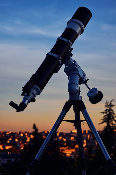istock Big astronomical telescope under a twilight sky ready for stargazing. 1409485753