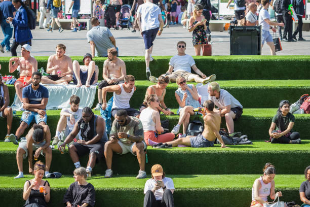 Heatwave in London, crowd on the Canalside Steps of Granary Square in Kings Cross, London, England stock photo