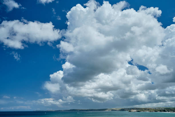 The Cornish Coastline at Newquay, Cornwall on a bright summer day with a dramatic cloudscape sky.