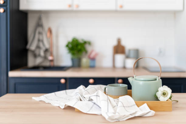 istock Green kettle and mug with tea and towel on table 1409492915