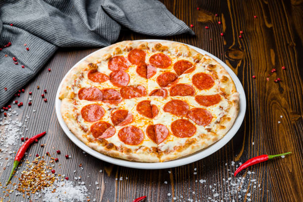 istock Pepperoni pizza on plate on wooden table 1409494625