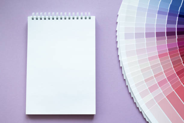 istock Paint samples, multicolors swatch for interior design. Red, pink, purple and violet with lilac colors. Light lilac background. White paper notebook for drawing or writing. Copy space 1409496922