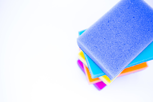 Top view of sponges for washing dishes, on a white background, isolated. Colorful multi-colored as rainbow sponges lay one each other.