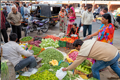 Jaipur, India - January 7, 2020: Women buying vegetables on the street in Jaipur, Rajasthan, India. Jaipur is the capital and largest city of the Indian state of Rajasthan in Northern India.