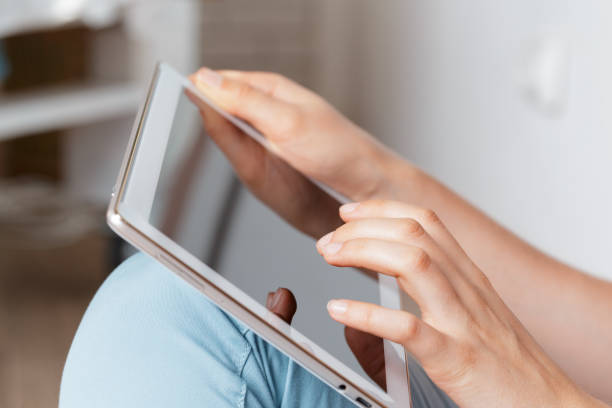 istock woman holding digital tablet, closeup 1409501383