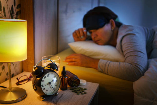 istock Woman with insomnia looking at the time on her alarm clock 1409501880