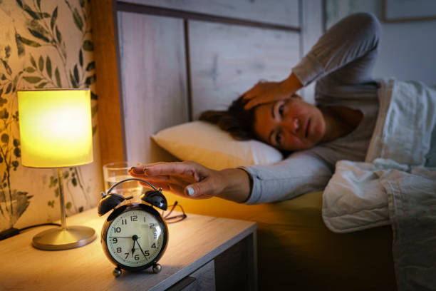 istock Tired woman waking up with a headache 1409501923