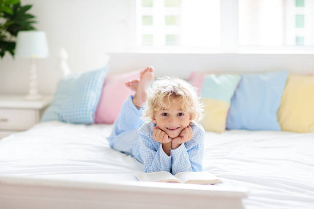 child reading book in bed. kids read in bedroom. - 6707 imagens e fotografias de stock