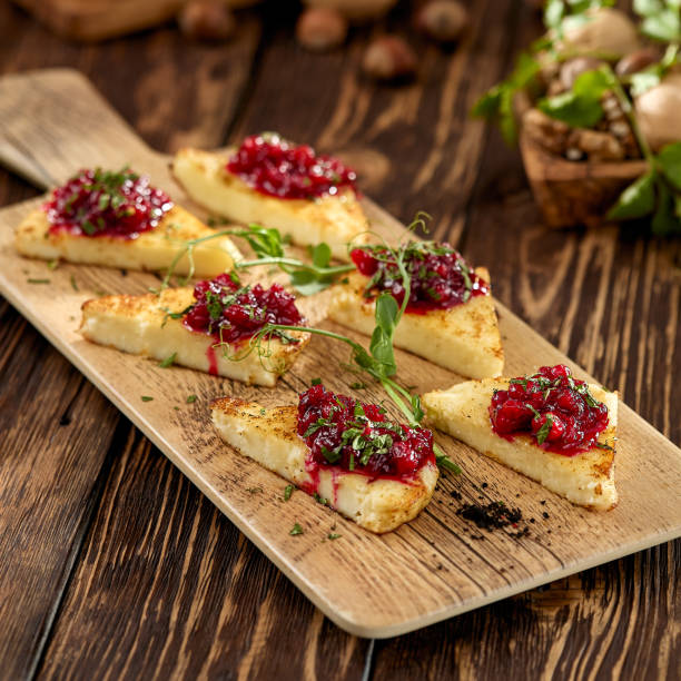 istock Hot appetizer for wine - grilled halloumi cheese with jam. Cheese appetizer baked halloumi on wooden background on rustic style. Adyghe cheese with berries dip on wooden table. 1409503344