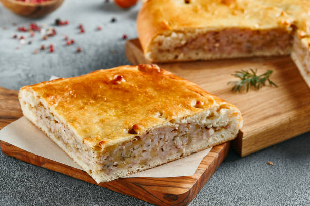 istock Classic chicken and potato pie on wooden board with ingredients. Composition with chicken pie on concrete background with textile and spices. Homemade pie with turkey and potato in rustic style. 1409503362