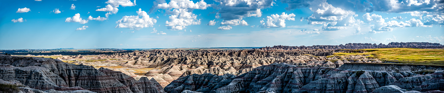 Male hiker looking with binoculars enjoying the landscape of the Badlands National Park while standing on a trail.