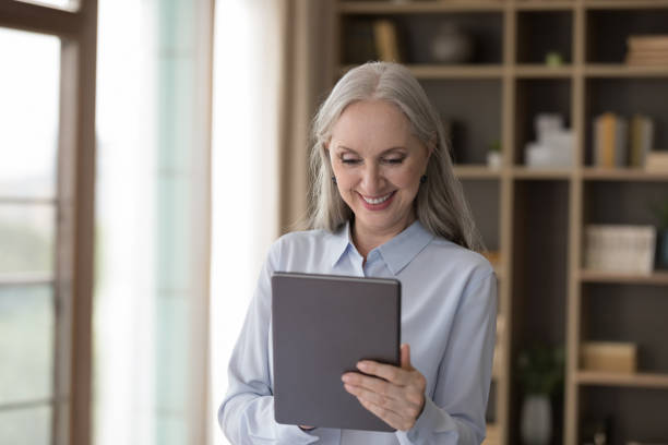 istock Smiling middle-aged businesslady working online use digital tablet 1409509227