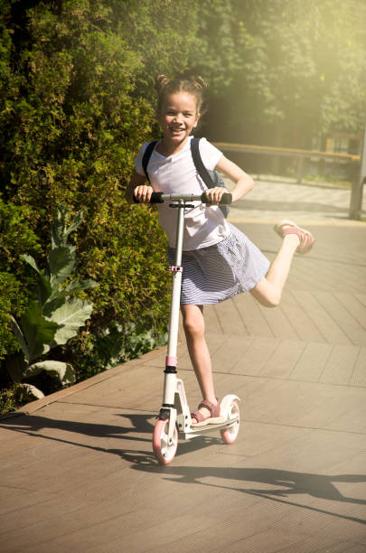 istock A girl in the park rides a scooter 1409509477