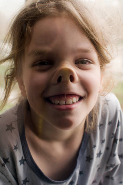 The girl is making faces at the window