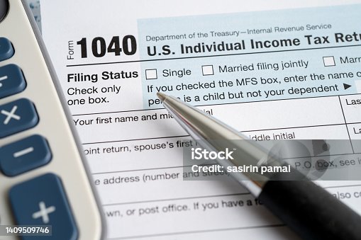 istock Tax Return form 1040 with USA America flag and dollar banknote, U.S. Individual Income. 1409509746