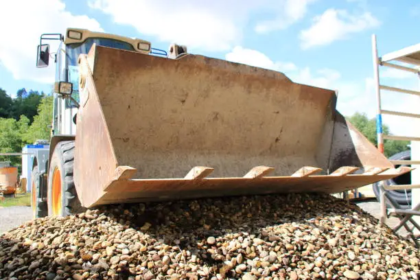 Shovel from a wheel loader was placed on a pile of gravel and photographed from a frog's perspective