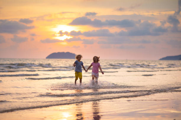 istock Child playing on ocean beach. Kid at sunset sea. 1409511640