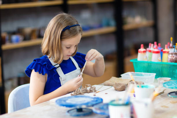istock Child at pottery wheel. Kids arts and crafts class 1409513853