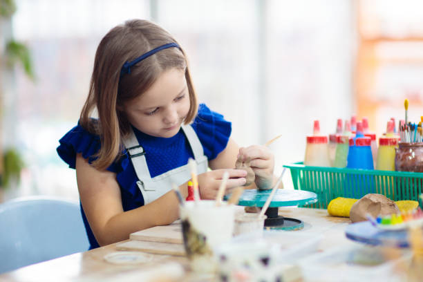istock Child at pottery wheel. Kids arts and crafts class 1409513879