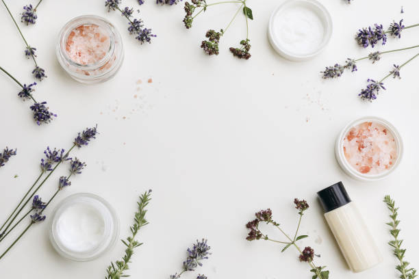 Skin cream, moisturizer and shampoo bottle. Lavender, oregano and satureja herbs with Himalayan salt. White table background. Beauty frame, web banner. Organic cosmetics, spa concept. Flat lay, top view. stock photo
