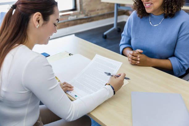 istock Human resources representative reviews contract as woman waits 1409517577