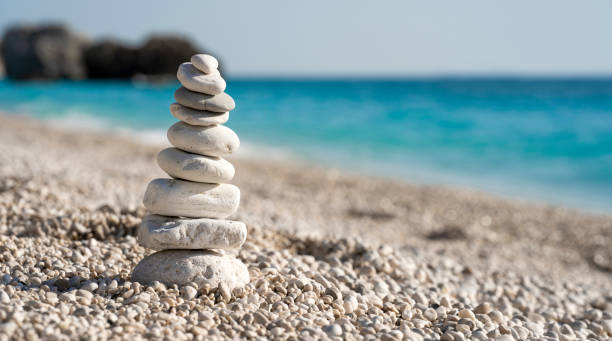 istock Stacked stones on a beautiful white pebble beach 1409518866