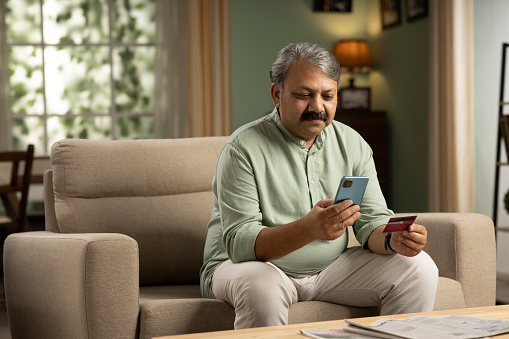 Mature man paying online on mobile phone
