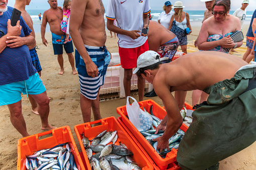 Almada, Portugal. July 13, 2022. Fishermans working in Fonte da Telha beach in Almada Portugal