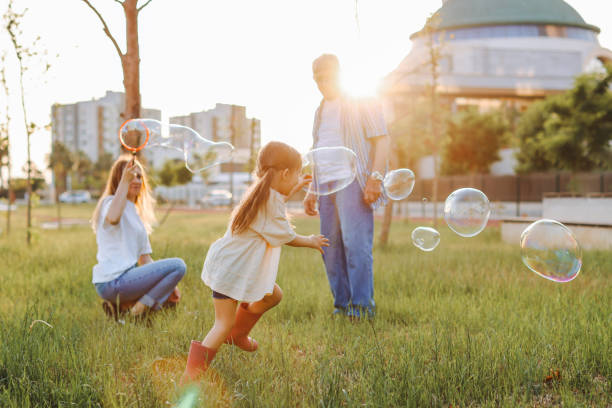 istock Happy family blowing soap bubbles in the park. 1409523532
