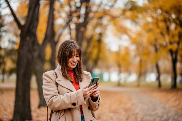 istock Young Woman Walking In The Park And Using Phone 1409523850