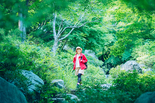 Young woman enjoying a mountain road surrounded by fresh greenery