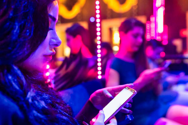 istock Girl in a nightclub using cell phone 1409526217