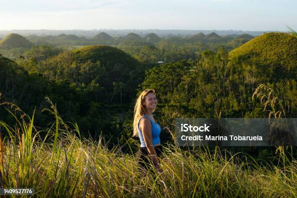 A Happy Young Woman Enjoys A Panoramic View At Sunset In The Chocolate Hills Of Bohol Philippines Stock Photo - Download Image Now