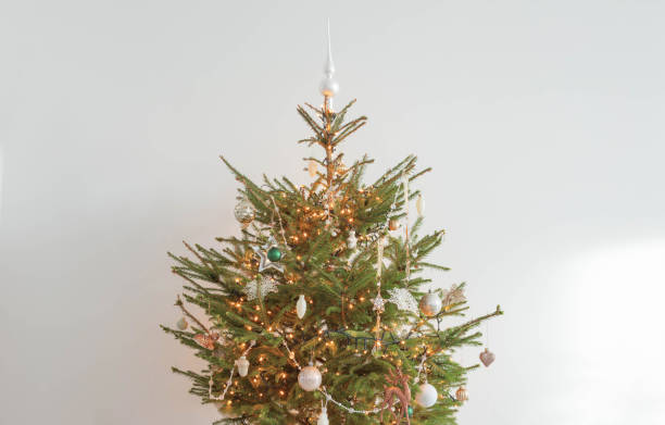 istock christmas tree with decor and lights in white room 1409527622