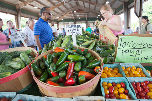 Raleigh, North Carolina, USA - 07/16/2022:  Customers purchasing fresh corn and other vegetables at State Farmers Market in Raleigh, North Carolina, USA