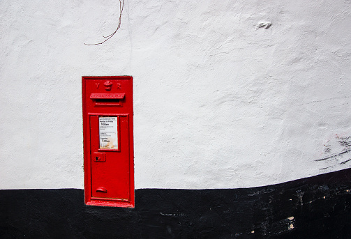 Topsham, Devon England- March 21st 2022:A Victorian post box embedded in a common wall in Topsham Devon, a rare sight.