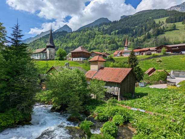 スイスアルプススイスのグリュイエールの上にあるフリブール州のブル近くの山の村jaunの春の小さな素朴な礼拝堂とシャレー - waterfall footbridge switzerland rapid ストックフォトと画像