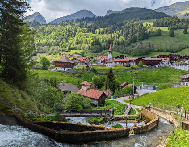 mała rustykalna kaplica i domek na wiosnę w górskiej wiosce jaun w pobliżu bulle w kantonie fryburg nad gruyere w alpach szwajcarskich szwajcaria - waterfall footbridge switzerland rapid zdjęcia i obrazy z banku zdjęć
